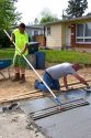 Workers leveling a newly poured concrete driveway in Boise, Idaho.