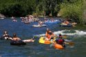 People on inflatable rafts and a kayak floating the Boise River in Boise, Idaho.