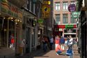 People and store fronts on a walking street in the Red Light District of Amsterdam, Netherlands.