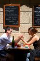 A young couple in love dine at a sidewalk cafe in Saint-Malo in Brittany, northwestern France.