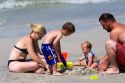 Family plays in the sand on the beach at St. Petersburg, Florida. MR