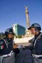 Female police officers write a traffic ticket in front of El Angel de la Independencia in Mexico City, Mexico.