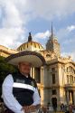 A police officer wearing a sombrero in front of the Palace of Fine Arts in Mexico City, Mexico.