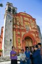Tour guide and tourists in front of an old cathedral in Cuernavaca in the State of Morelos, Mexico.