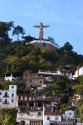 A Christ statue sits above homes built on the hillside at Taxco in the State of Guerrero, Mexico.