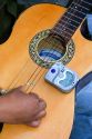Acoustic guitar being tuned with an electric tuner in Mexico City, Mexico.