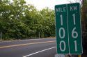 Roadside mile marker showing measurements in miles and kilometers on the Big Island of Hawaii.