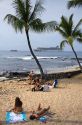 People on the beach with a cruise ship in the background near Kona on the Big Island of Hawaii.