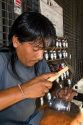 Steet vendor engraving a silver mate cup in Buenos Aires, Argentina.