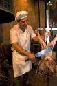 Argentine man cooking meat at a restaurant in Buenos Aires, Argentina.