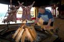Man cooking lamb meat over an open fire in a restaurant at Ushuaia on the island of Tierra del Fuego, Argentina.