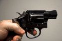 Finger on the trigger of a Smith and Wesson .38 caliber snub nose revolver.