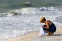 Beachcomber searching for seashells on the beach at Sanibel Island on the Gulf Coast of Florida.