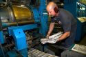 Pressman pulling newspapers from the rotary printing press for the Houston Chronicle in Houston, Texas.