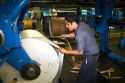 Pressman loading a large roll of paper on to a rotary printing press for the Houston Chronicle in Houston, Texas.