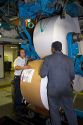 Pressmen loading large rolls of paper on to a rotary printing press for the Houston Chronicle in Houston, Texas.