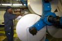 Pressman loading large rolls of paper on to a rotary printing press for the Houston Chronicle in Houston, Texas.