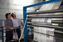 Pressmen inspect newspapers being printed on a rotary printing press for the Houston Chronicle in Houston, Texas.