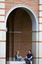 Students sit under an archway at Lovett Hall on the campus of William Marsh Rice University in Houston, Texas.