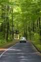 Auto driving through a wooded area of the Sleeping Bear Dunes National Lakeshore located along the northwest coast of the Lower Peninsula of Michigan.