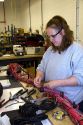 Female worker with wiring harness assembly at Spartan Motors truck chassis manufacturing in Charlotte, Michigan.