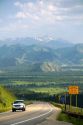 A vehicle travels over the high mountain Teton Pass on Wyoming Highway 22 near the state border of Wyoming and Idaho.