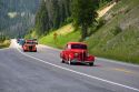 Classic American cars traveling over the high mountain Teton Pass on Wyoming Highway 22 near the state border of Wyoming and Idaho.