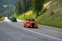Classic American cars travel over the high mountain Teton Pass on Wyoming Highway 22 near the state border of Wyoming and Idaho.