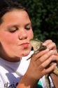 11 year old girl kissing a bullfrog in Boise, Idaho. MR