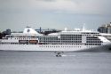 Seaplane taking off in front of the Silversea Silver Shadow cruise ship at Port Vancouver in British Columbia, Canada.