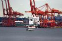 Seaplane taking off in front of a container ship at Port Vancouver in British Columbia, Canada.