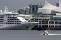Seaplane taking off in front of the Silversea Silver Shadow cruise ship at Port Vancouver in British Columbia, Canada.