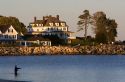 Waterfront home and man fishing at the village of Hampton Beach, New Hampshire, USA.