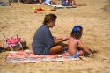 Mother applying sunscreen to her daughter on the beach at La Concha Bay in the city of Donostia-San Sebastian, Guipuzcoa, Basque Country, Northern Spain.