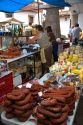 Vendor selling cheese and meats at an outdoor market in the town of Cangas de Onis, Asturias, northern Spain.