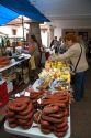 Vendor selling cheese and meats at an outdoor market in the town of Cangas de Onis, Asturias, northern Spain.