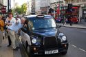 Hackney taxi cab driver giving directions to a pedestian in the city of London, England.