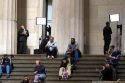 News reporters on the steps of Federal Hall located at 26 Wall Street in New York City, New York, USA.