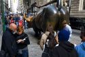Tourists gather around the Wall Street Bull in Bowling Green park near Wall Street, New York City, New York, USA.