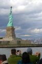 Tourists view the Statue of Liberty from New York Harbor in New York, USA.