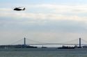 Navy helicopter flying near the Verrazano-Narrows Bridge in New York Harbor, New York, USA.