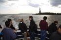 Tourists view the Statue of Liberty from a ferry boat in New York Harbor, New York, USA.