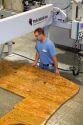 Worker custom cutting a granite countertop at the Shaker Hill Granite Company located in the town of Enfield, New Hampshire, USA.