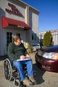 Handicapped insurance claims adjuster assessing the damage of an automobile in Boise, Idaho, USA. MR