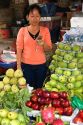 Vendor selling produce and using a cell phone at a market in the Cholon district of Ho Chi Minh City, Vietnam.