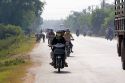 Vietnamese people ride motorbikes on a road near Tay Ninh, Vietnam.