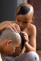 Novice Buddhist monks shave each other's heads at the Thien Mu Pagoda along the Perfume River in Hue, Vietnam.
