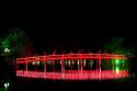 The Huc Bridge lit at night on Hoan Kiem Lake in Hanoi, Vietnam.