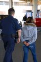 U.S. Customs and Immigration agent escorting a suspected illegal alien handcuffed at the United States port of entry at the Tijuana, Baja California, Mexico/San Diego, California border crossing.