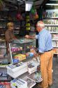 French man purchasing a newspaper from a Presse news kiosk in Sanary-sur-Mer, France.